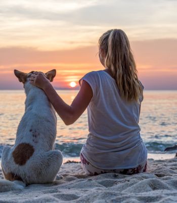 Frau mit Hund am Strand