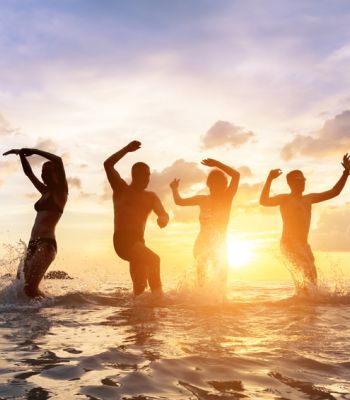 Menschen in der Nordsee beim Sonnenuntergang